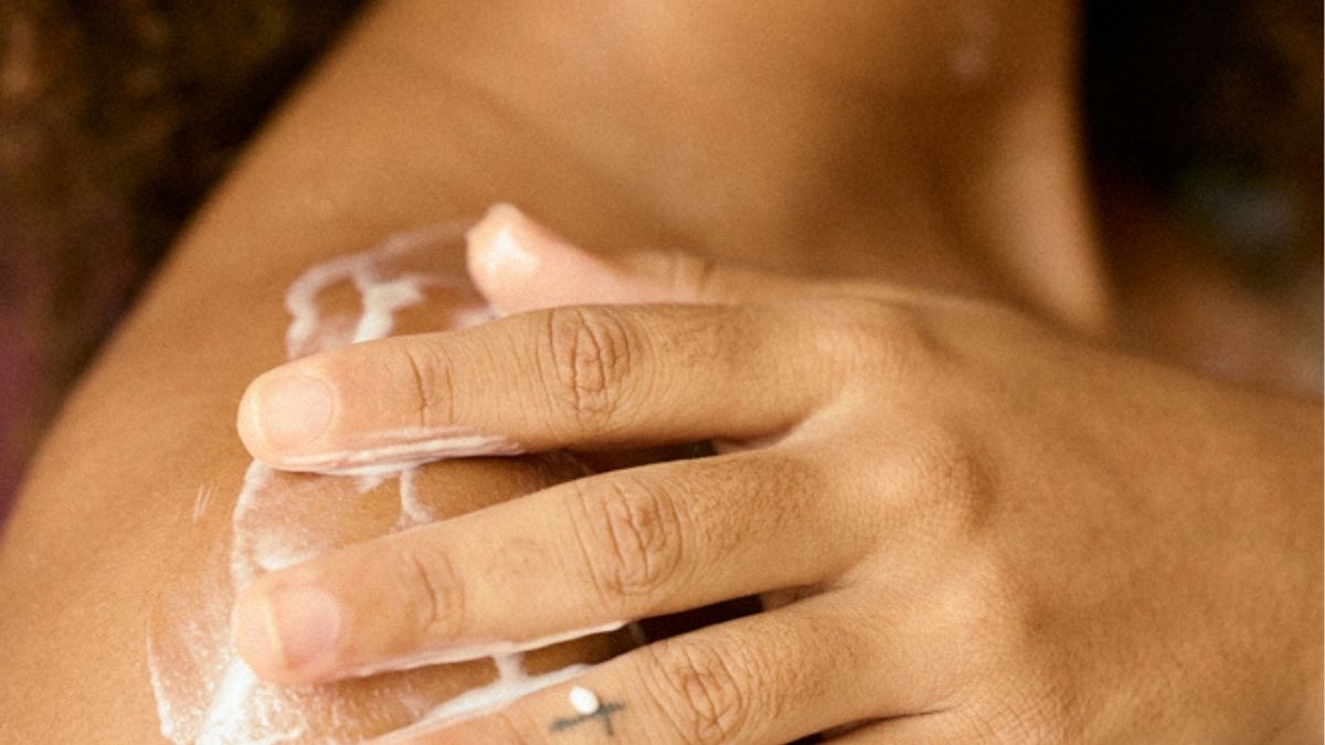 black woman applying tallow balm to her skin