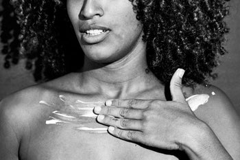 Hands massaging balm into skin — ritualistic self-care moment with natural light